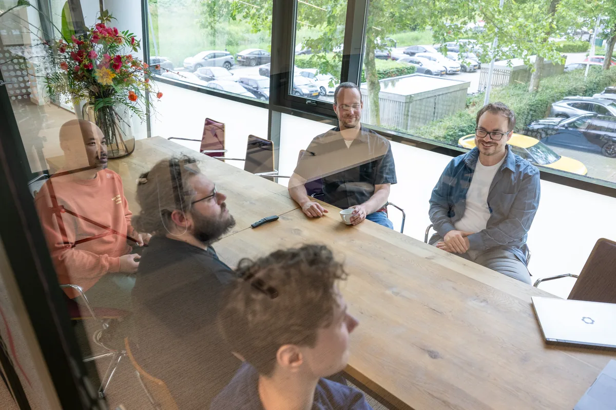 Gesprek met vijf Emendis-collega's aan een grote tafel