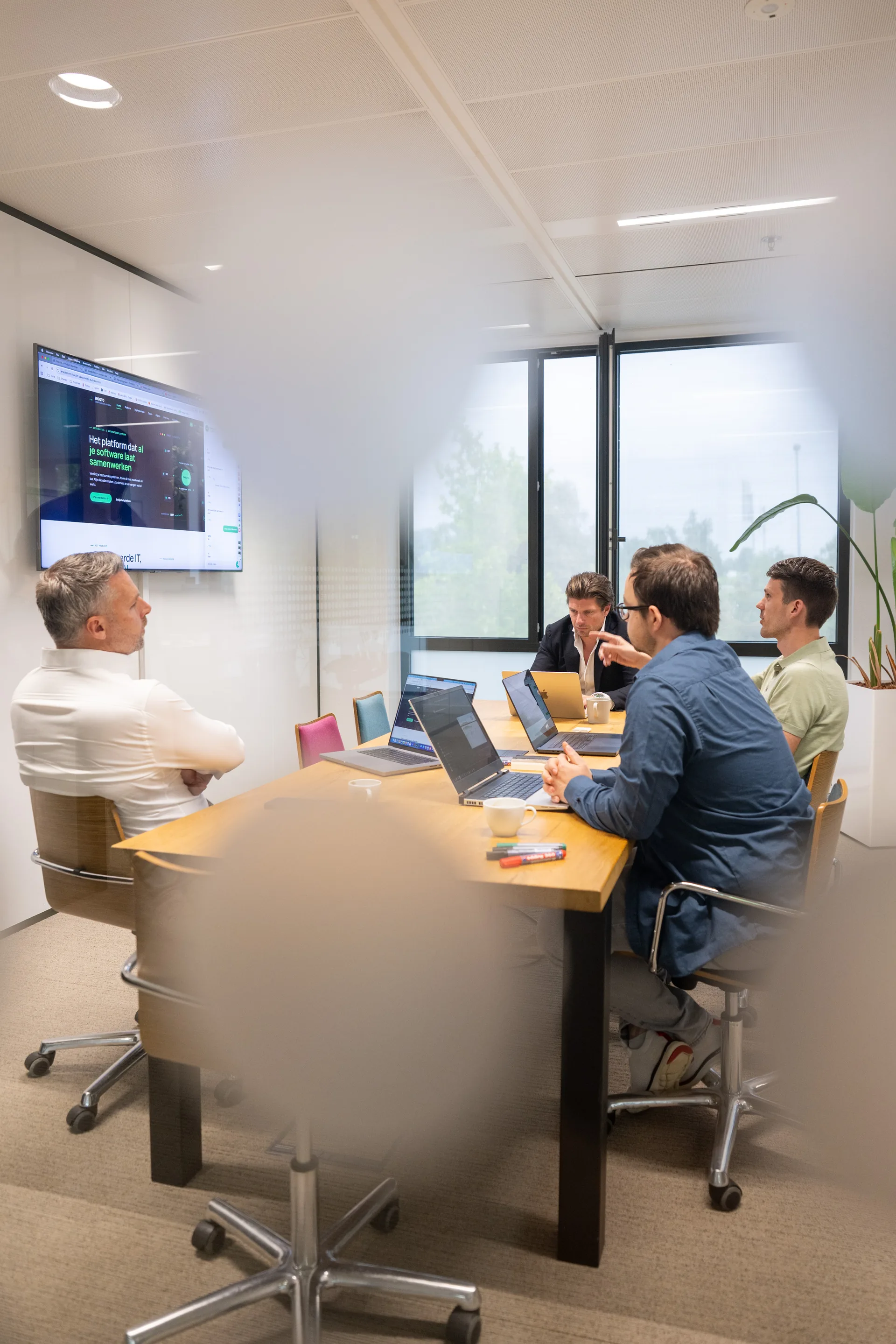 Emendis-consultants in overleg langs de glaswand in het kantoor in Veenendaal