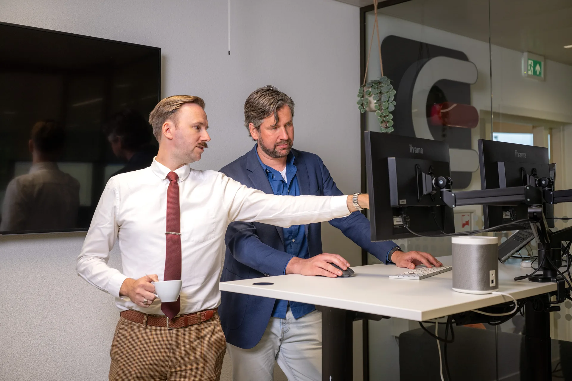 Twee Emendis-collega's bij een bureau tijdens het werk in het kantoor in Veenendaal